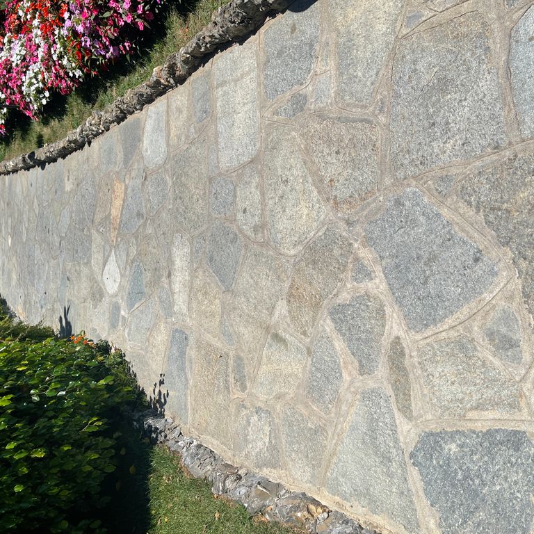 Application image for Pietra Italia Full Color Gneiss - Irregular Pavers. The image shows this product being used in a path pavers application. The surface finish shown is natural cleft. Dominant colors shown are beige and gray. The color mix creates a warm feeling.