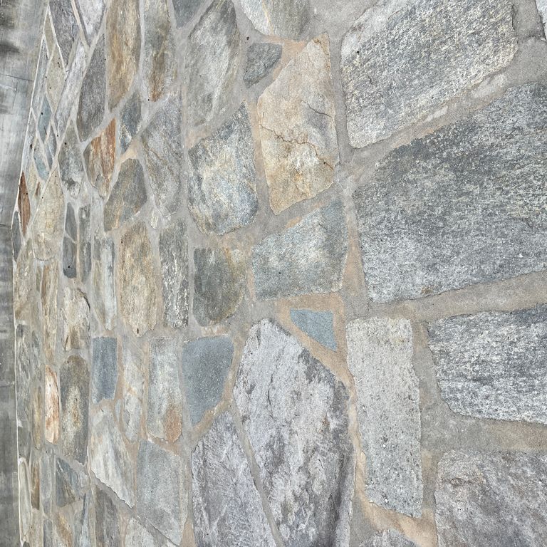 Application image for Pietra Italia Full Color Gneiss - Irregular Pavers. The image shows this product being used in a patio pavers application. The surface finish shown is natural cleft. Dominant colors shown are beige and gray. The color mix creates a warm feeling.