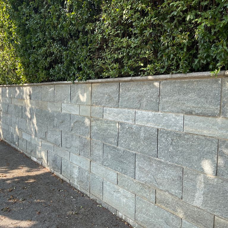 Application image for Pietra Italia Full Color Gneiss - Veneer. The image shows this product being used in a full bed veneer application. The surface finish shown is natural cleft. The dominant color shown is gray. The color mix creates a warm feeling.