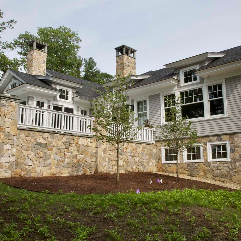 Feature image for Black Mountain Granite Natural - Veneer. The image shows this product being used in a thin veneer application. The surface finish shown is split-face. Dominant colors shown are brown and gray; with beige, black, blue, brown, orange/rust, purple, white and tan secondaries. The color mix creates a warm feeling. Regular color pattern.