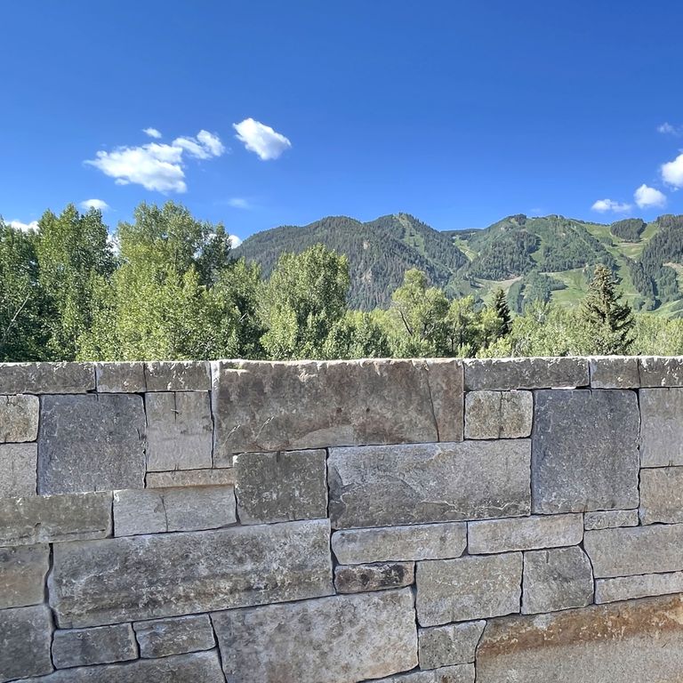 Application image for Reclaimed Granite Curbstone - Full Bed Veneer. The image shows this product being used in a full bed veneer application. Dominant colors shown are gray and tan. Exhibits 