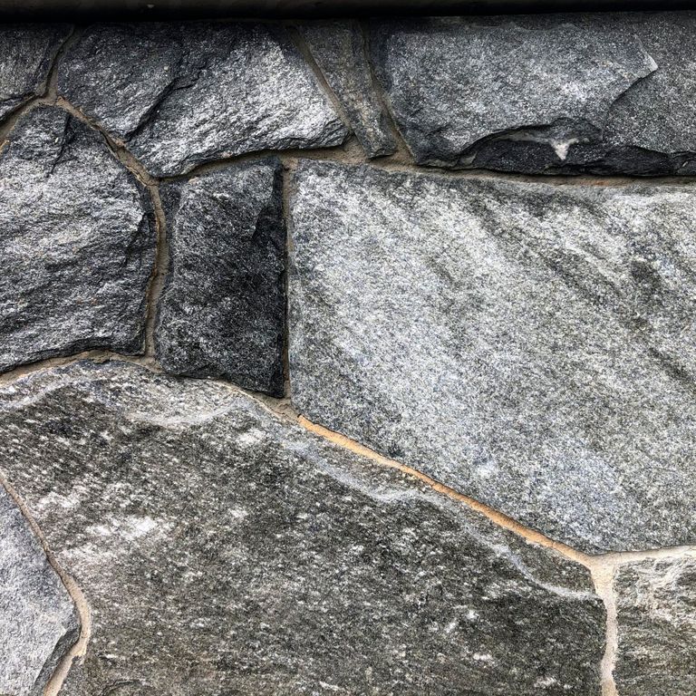 Best close-up image for Old Chester Granite - Veneer - Bed/Seam Splitface Splitface. The image shows this product being used in a thin veneer application. The surface finish shown is . The dominant color shown is gray. Regular color pattern. Contains some mica.