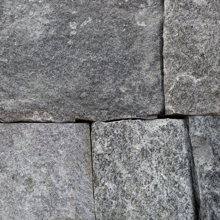 Feature image for Old Chester Granite - Veneer - Bed/Seam Splitface Splitface. The image shows this product being used in a thin veneer application. The dominant color shown is gray. The color mix creates a cool feeling. Regular and random color patterns. Contains some mica.