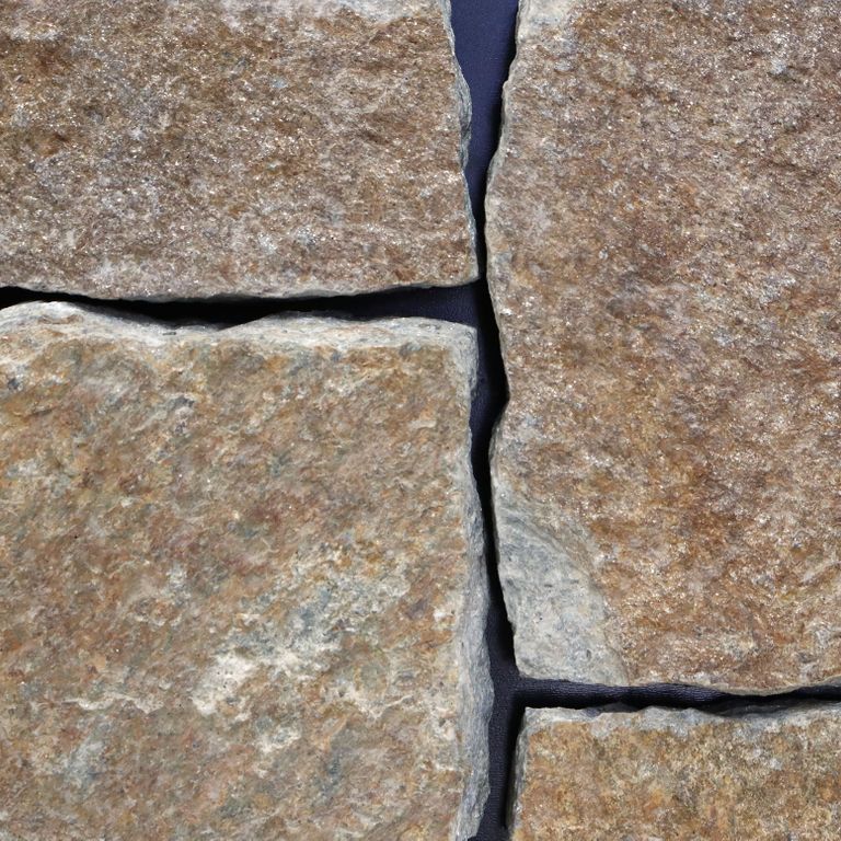 Feature image for Quaker Hill Tan Granite - Veneer - Splitface - Seam Face. The image shows this product being used in a thin veneer application. The surface finish shown is . Dominant colors shown are brown and gray. The color mix creates a warm feeling. Regular and blotched color patterns.