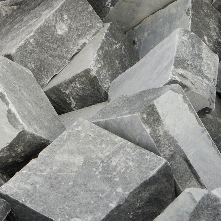Best close-up image for Polar Gray Limestone Cobblestones. The surface finish shown is flamed. The dominant color shown is gray. Regular color pattern.