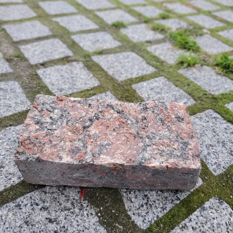 Application image for Granite - Red Crystal - Cobblestone. The image shows this product being used in a patio pavers application. Dominant colors shown are gray and red. The color mix creates a warm feeling.