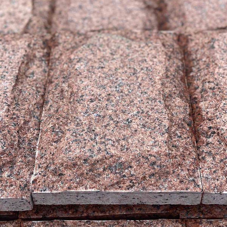Best close-up image for Granite - Red Pomegranate - Veneer. The surface finish shown is split-face. Dominant colors shown are brown, orange/rust and red. The color mix creates a warm feeling.