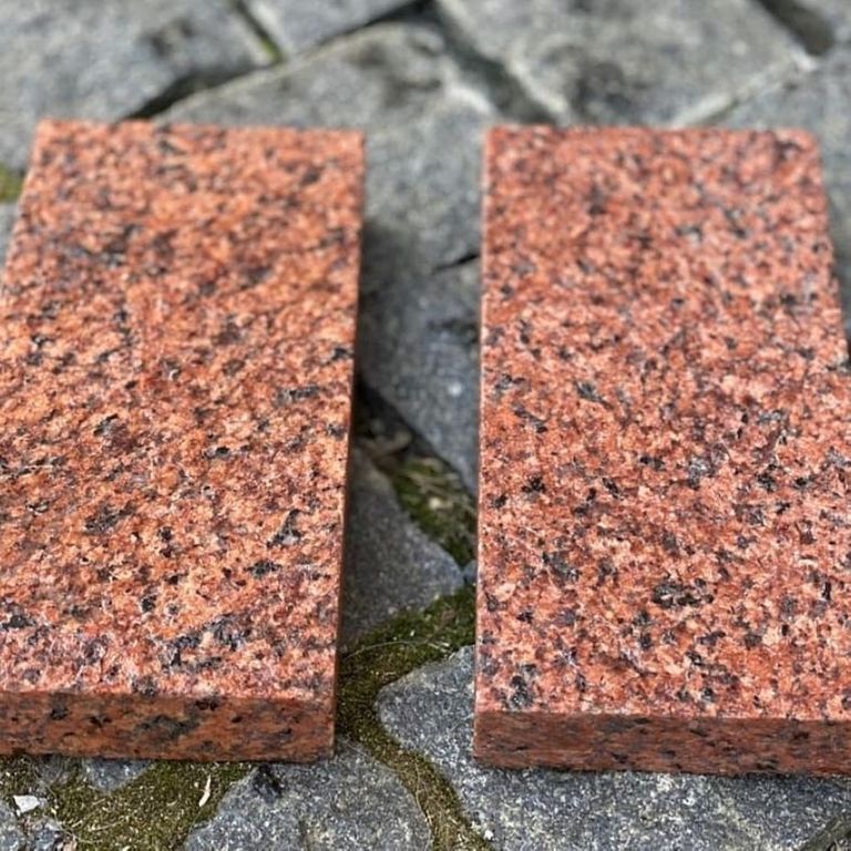 Application image for Granite - Red Pomegranate - Cobblestone. The image shows this product being used in a patio pavers application. The surface finish shown is flamed. Dominant colors shown are orange/rust and red. The color mix creates a warm feeling.