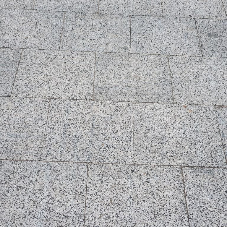 Application image for Granite - White House - Pavers. The image shows this product being used in a patio pavers application. The surface finish shown is flamed. Dominant colors shown are gray and white. The color mix creates a cool feeling.