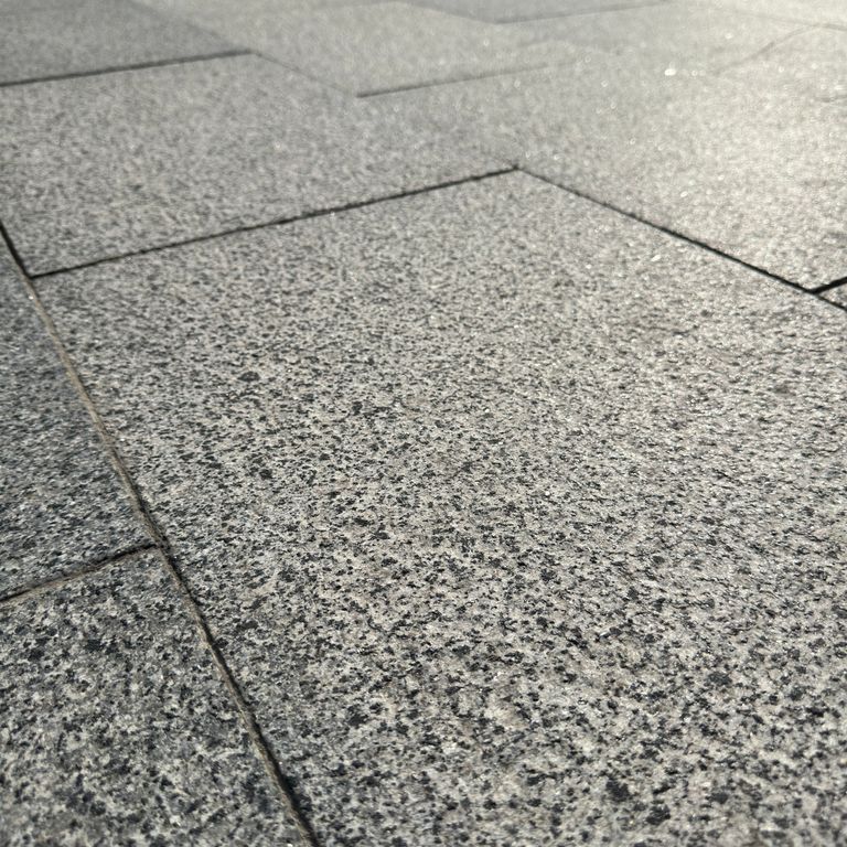 Application image for Granite - White House - Pavers. The image shows this product being used for path pavers and patio pavers. The surface finish shown is flamed. Dominant colors shown are gray and white.