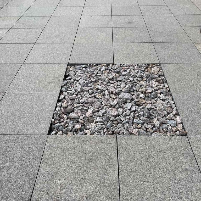 Feature image for Gabbro - Dark Magma - Pavers. The image shows this product being used in a path pavers application. The surface finish shown is flamed. The dominant color shown is gray. The color mix creates a cool feeling.