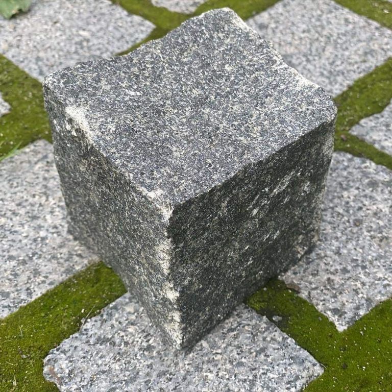 Feature image for Gabbro - Dark Magma - Cobblestones. The image shows this product being used in a patio pavers application. The dominant color shown is gray. The color mix creates a warm feeling.