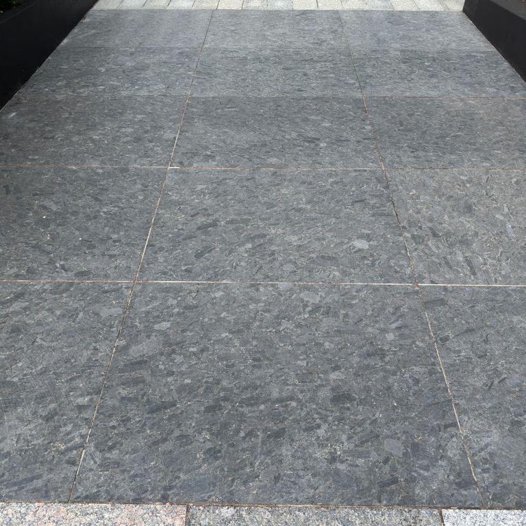 Application image for Granite - Labradorite - Blue Seven Oceans - Pavers. The image shows this product being used in a path pavers application. The surface finish shown is honed. The dominant color shown is gray. The color mix creates a warm feeling.