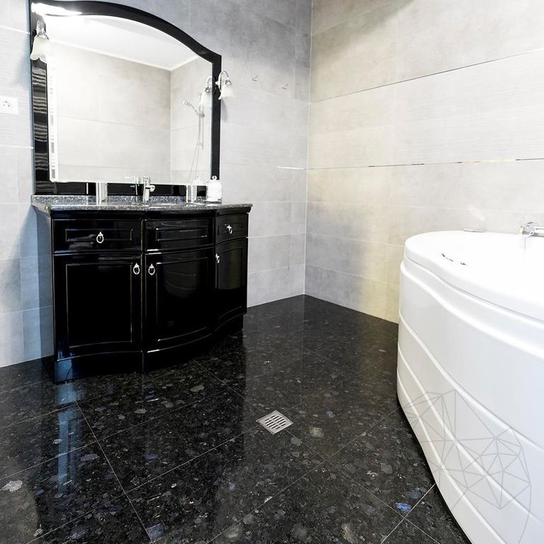 Application image for Labradorite - Blue Seven Oceans - Interior Tiles. The image shows this product being used in an interior floor application. The surface finish shown is polished. The dominant color shown is black. The color mix creates a cool feeling.