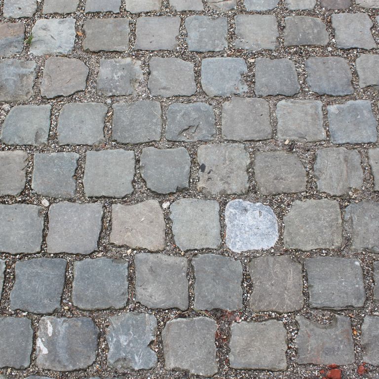 Best close-up image for Reclaimed European Porphyry Cobblestones - Square - Antiqued. The image shows this product being used for driveway pavers, path pavers, patio pavers and driveway aprons. The surface finish shown is . The dominant color shown is gray. The color mix creates a warm feeling.