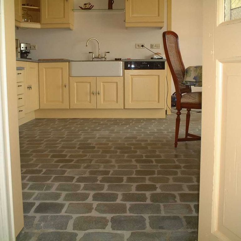 Application image for Porphyry - Reclaimed European Cobblestone - Rectangle - Flat Surface. The image shows this product being used in an interior floor application. The surface finish shown is sawn. Dominant colors shown are brown and tan. The color mix creates a warm feeling.