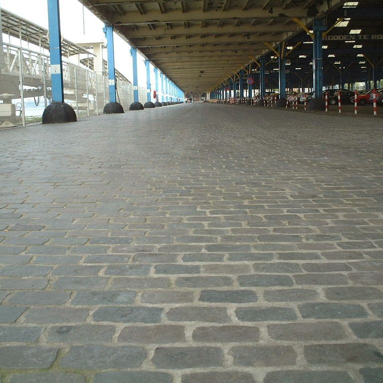 Application image for Porphyry - Reclaimed European Cobblestones - Rectangle - Flat Surface. The image shows this product being used in a public area application. The surface finish shown is sawn. The dominant color shown is gray. The color mix creates a cool feeling.