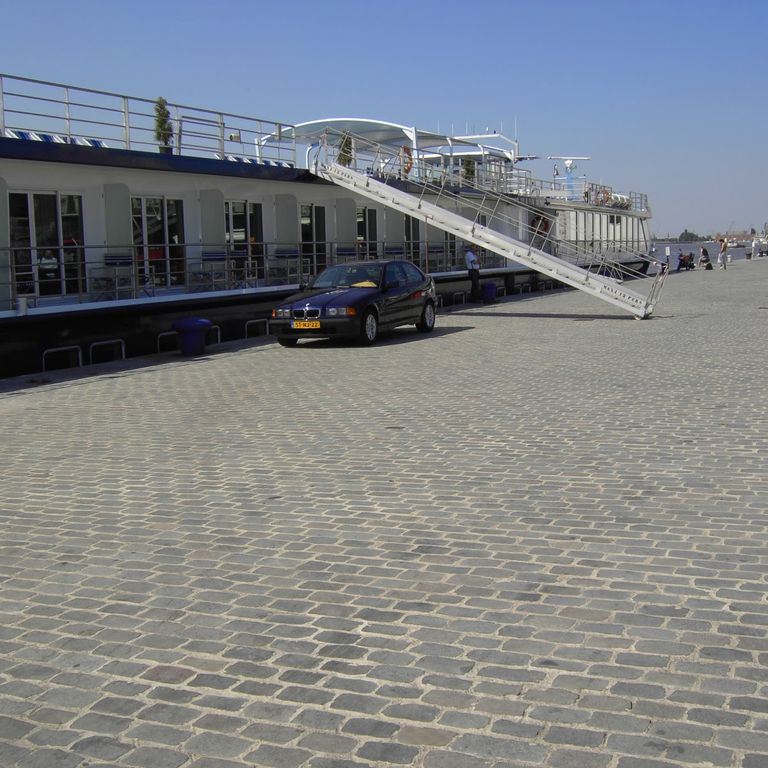 Application image for Porphyry - Reclaimed European Cobblestones - Rectangle - Flat Surface. The image shows this product being used for driveway pavers, path pavers and patio pavers. The surface finish shown is sawn. The dominant color shown is gray.