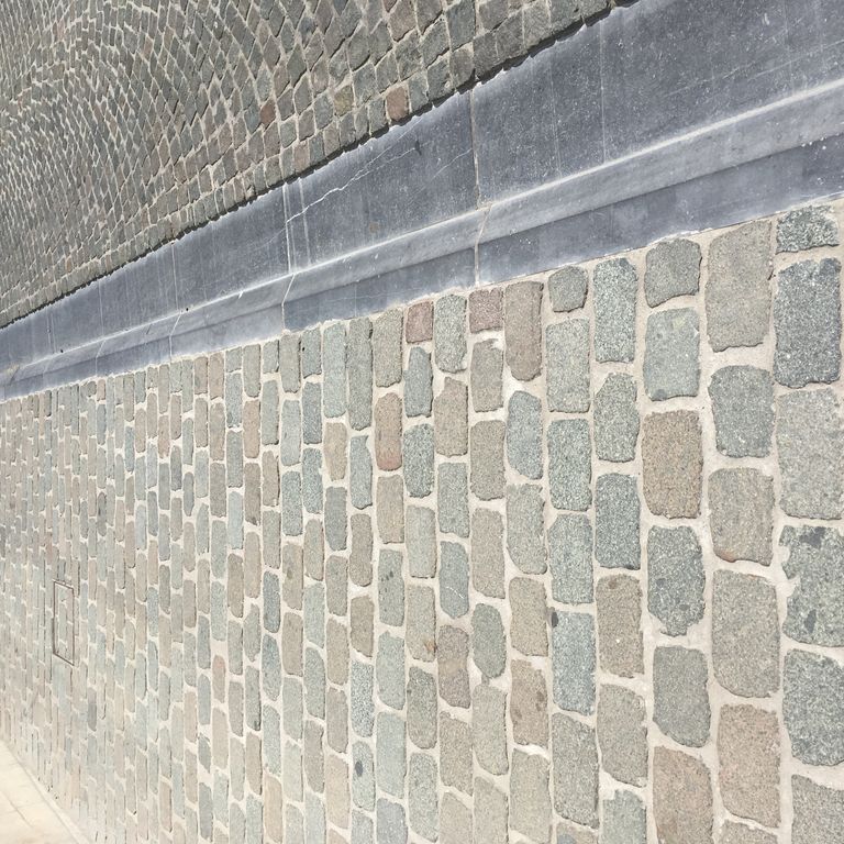 Application image for Porphyry - Reclaimed European Cobblestone - Rectangle - Flat Surface. The image shows this product being used in a path pavers application. Dominant colors shown are gray and tan. Fine speckled color pattern.