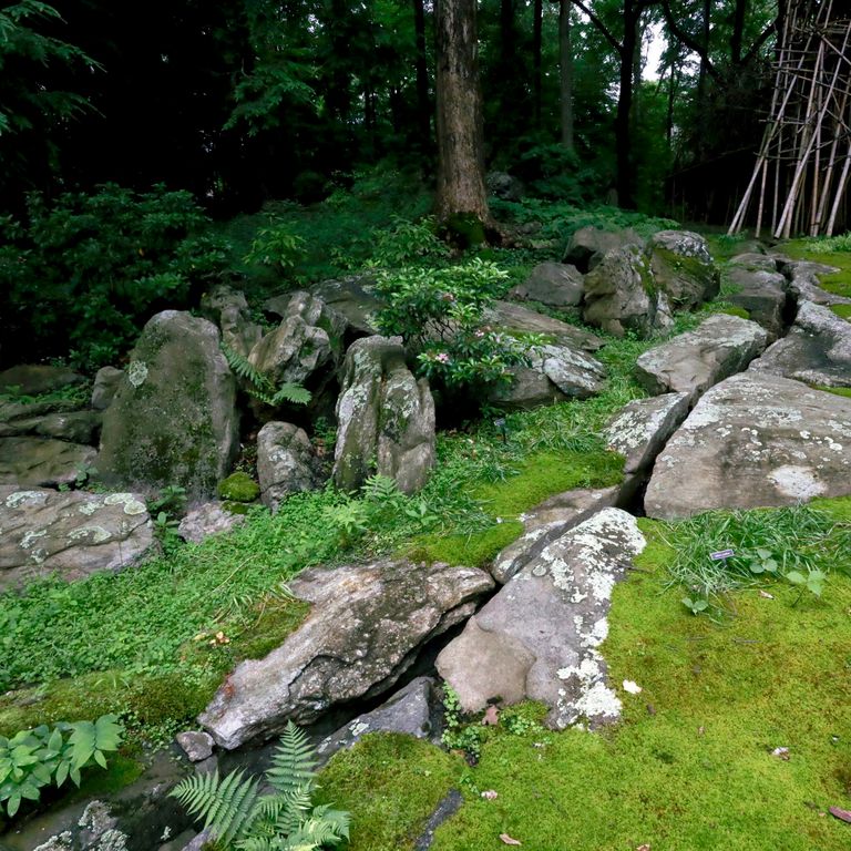 Application image for New England Fieldstone Boulders & Ledgestone - Pool/Pond Coping. The image shows this product being used for water features and garden accents. The surface finish shown is weathered. The dominant color shown is gray; with beige, brown, pink, purple, white, tan and cream secondaries. Exhibits 