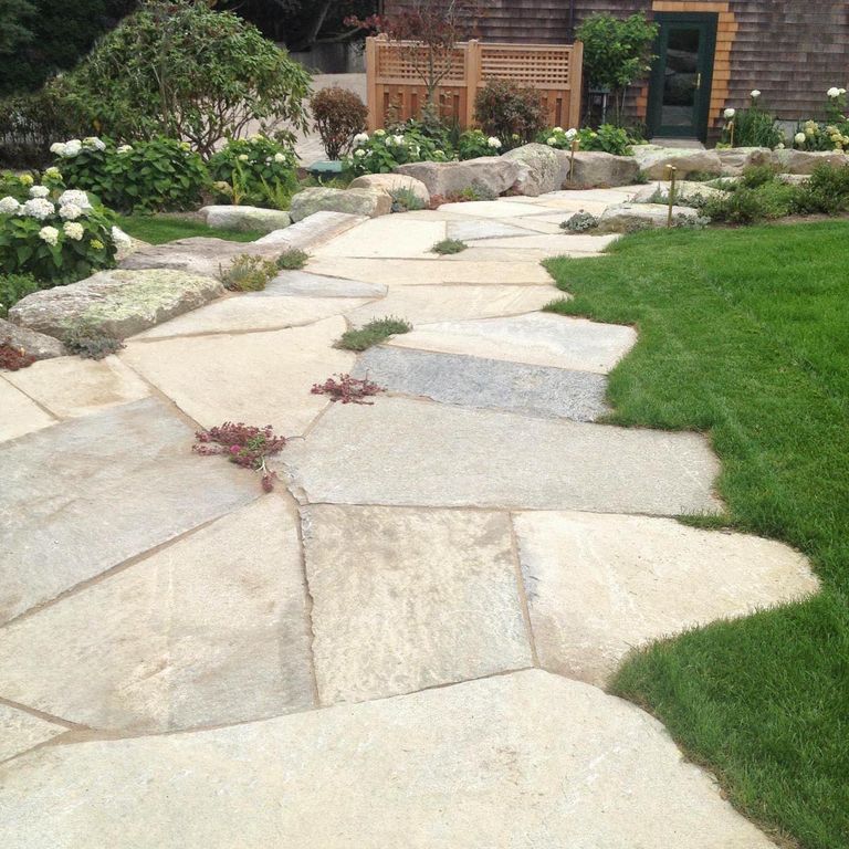 Feature image for Tidewater Granite Oversized Pavers. The image shows this product being used in a path pavers application. Design patterns shown are irregular flagging quarried-snapped and irregular flagging sawn flat edges & irregular sawn edges. Dominant colors shown are beige, tan and cream; with gray and white secondaries. Exhibits 