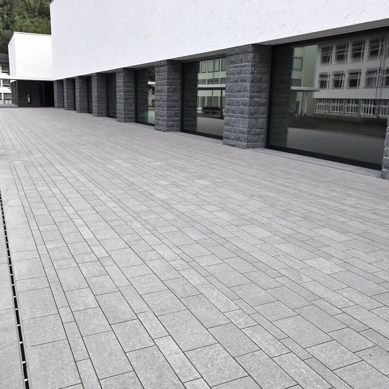Application image for Polar Gray Limestone - Dimensional Cut Pavers. The image shows this product being used in a patio pavers application. The surface finish shown is flamed. The dominant color shown is gray. The color mix creates a cool feeling. Regular color pattern.