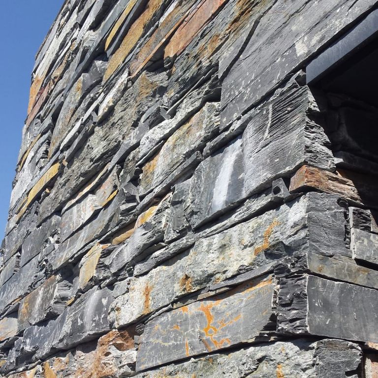 Application image for Slate - Iberian Gray - Veneer. The image shows this product being used for full bed veneer and thin veneer. The surface finish shown is split-face. The dominant color shown is gray. The color mix creates a warm feeling.