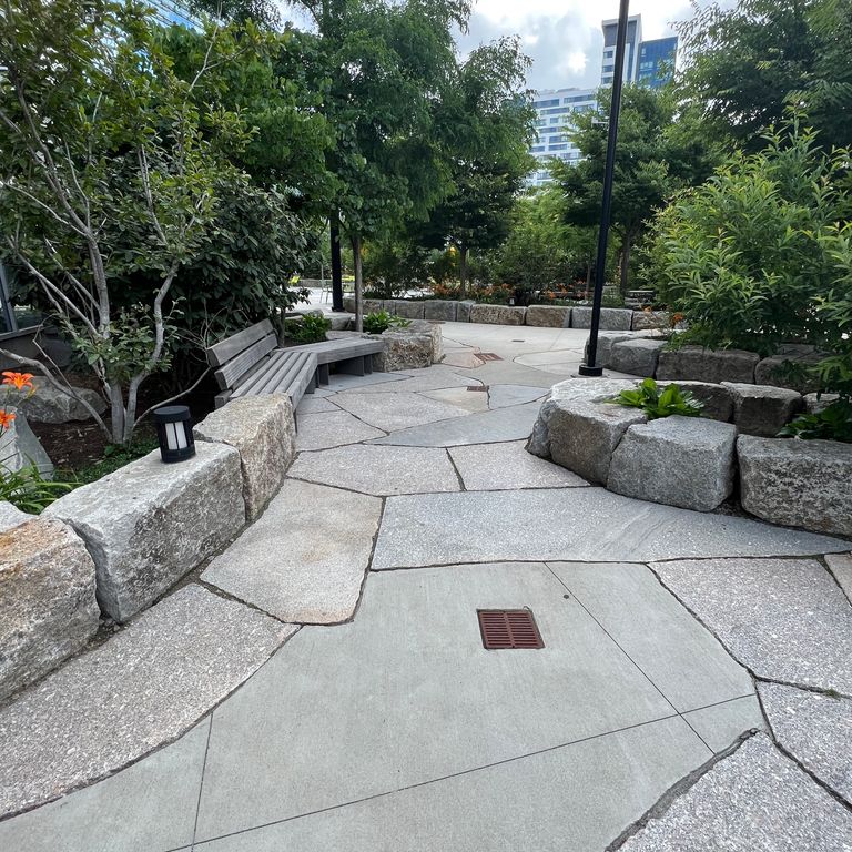 Application image for Reclaimed Granite Block - Seating Walls. The image shows this product being used for seating & benches and landscape curbing & edging. The dominant color shown is gray. The color mix creates a cool feeling.