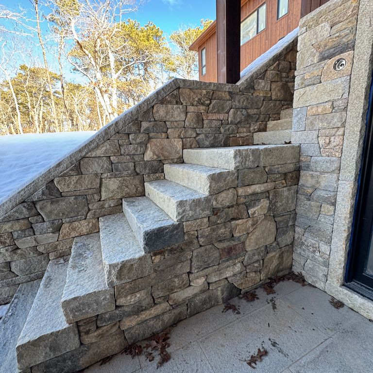 Application image for New England Fieldstone Mix - Veneer. The image shows this product being used in a full bed veneer application. The surface finish shown is weathered. The dominant color shown is gray.
