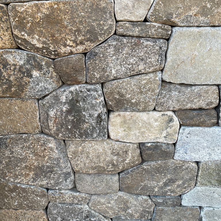 Application image for Fieldstone - New England Mix - Veneer. The image shows this product being used in a thin veneer application. The surface finish shown is weathered. The dominant color shown is gray. The color mix creates a warm feeling.