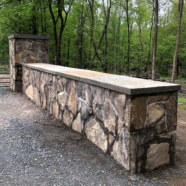 Application image for Fieldstone - Pennsylvania - Veneer. The image shows this product being used in a landscape wallstone application. Dominant colors shown are brown, gray and tan.