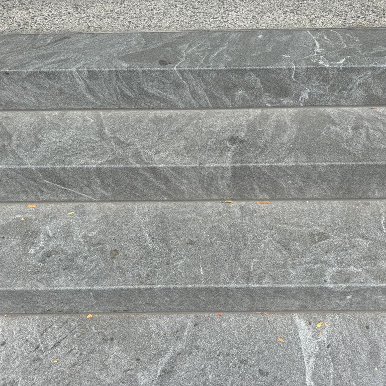 Application image for Granite - Jet Mist - Steps and Treads. The image shows this product being used in a monolithic steps application. The dominant color shown is gray. The color mix creates a warm feeling.