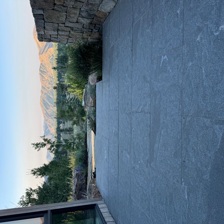 Application image for Granite - Jet Mist - Pavers. The image shows this product being used in a patio pavers application. The surface finish shown is flamed. The dominant color shown is gray.