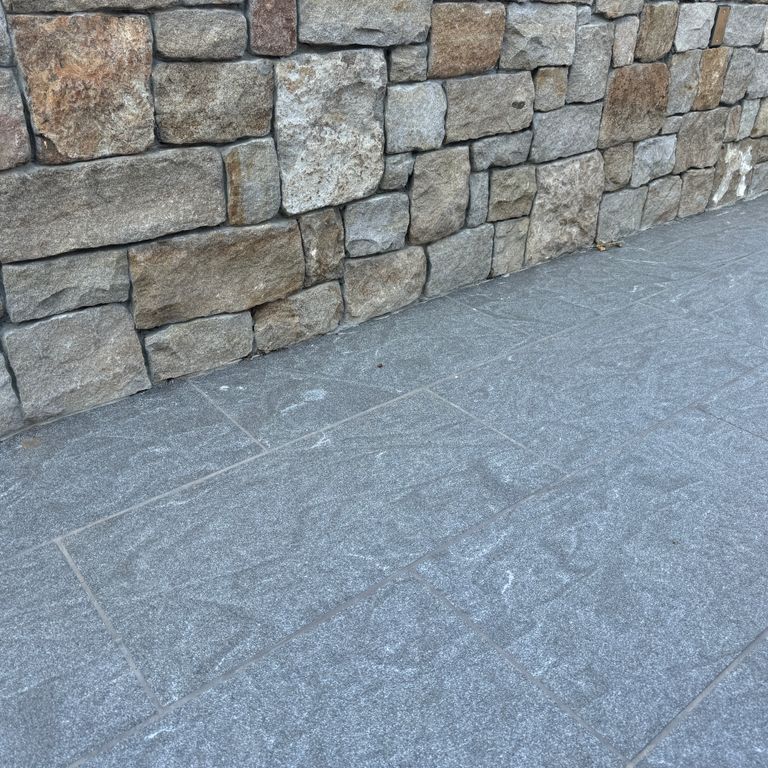 Application image for Granite - Jet Mist - Pavers. The image shows this product being used in a patio pavers application. The dominant color shown is gray. The color mix creates a cool feeling.