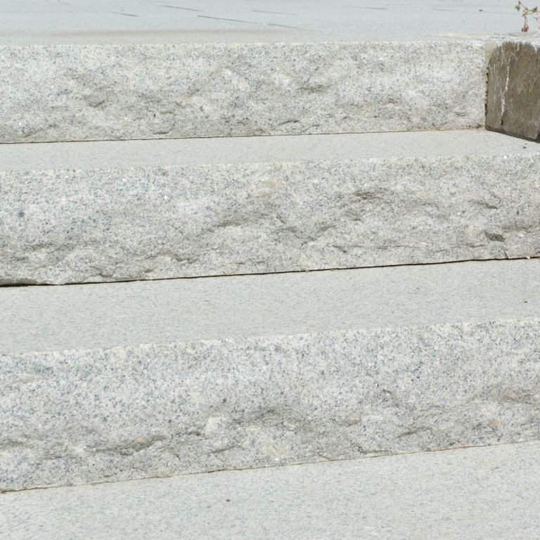 Close-up image for Cape Neddick Granite Clear - Rockfaced Steps. The surface finishes shown are flamed and rockfaced. Dominant colors shown are gray and white; with beige, pink and cream secondaries. Speckled and fine speckled color patterns.
