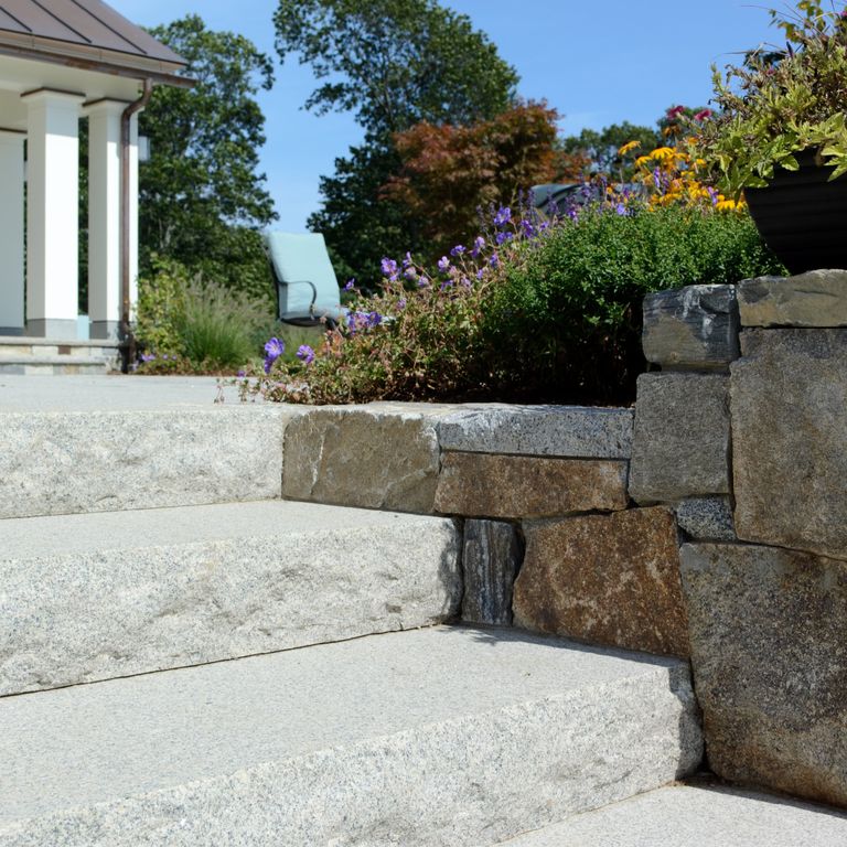 Application image for Cape Neddick Clear Granite - Dimensional Steps. The image shows this product being used in a monolithic steps application. The surface finish shown is flamed. The dominant color shown is gray.