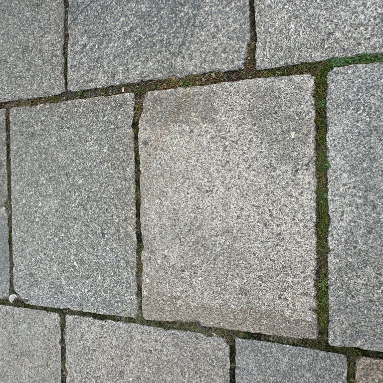 Best close-up image for Granite - Reclaimed Berlin Sidewalk Stones. The surface finish shown is . The dominant color shown is gray. The color mix creates a warm feeling.
