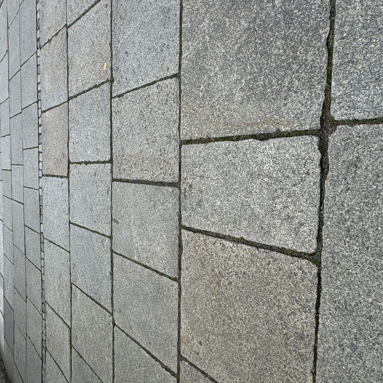 Feature image for Granite - Reclaimed Berlin Sidewalk Stones. The image shows this product being used in a patio pavers application. The surface finish shown is . The dominant color shown is gray. The color mix creates a cool feeling.
