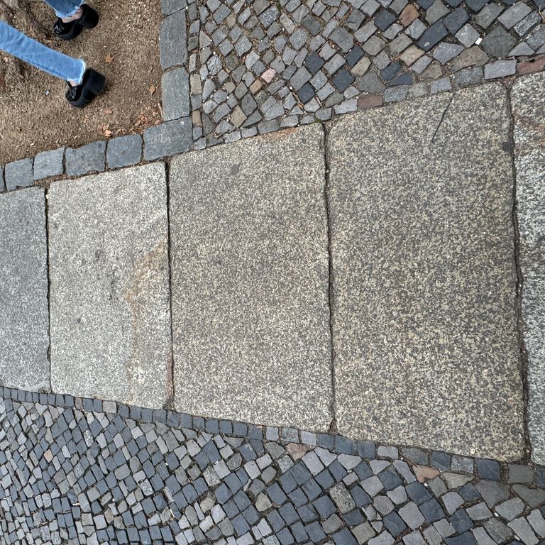 Application image for Granite - Reclaimed Berlin Sidewalk Stones. The image shows this product being used in a path pavers application. The surface finish shown is . The dominant color shown is gray. The color mix creates a cool feeling.