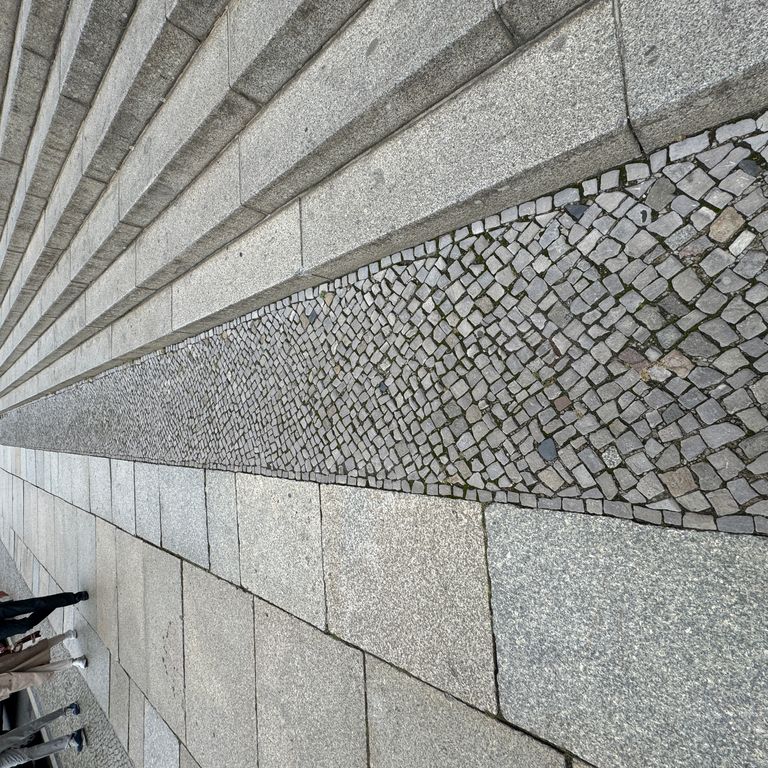 Application image for Granite - Reclaimed Berlin Sidewalk Stones. The image shows this product being used in a path pavers application. The surface finish shown is . The dominant color shown is gray. The color mix creates a cool feeling.