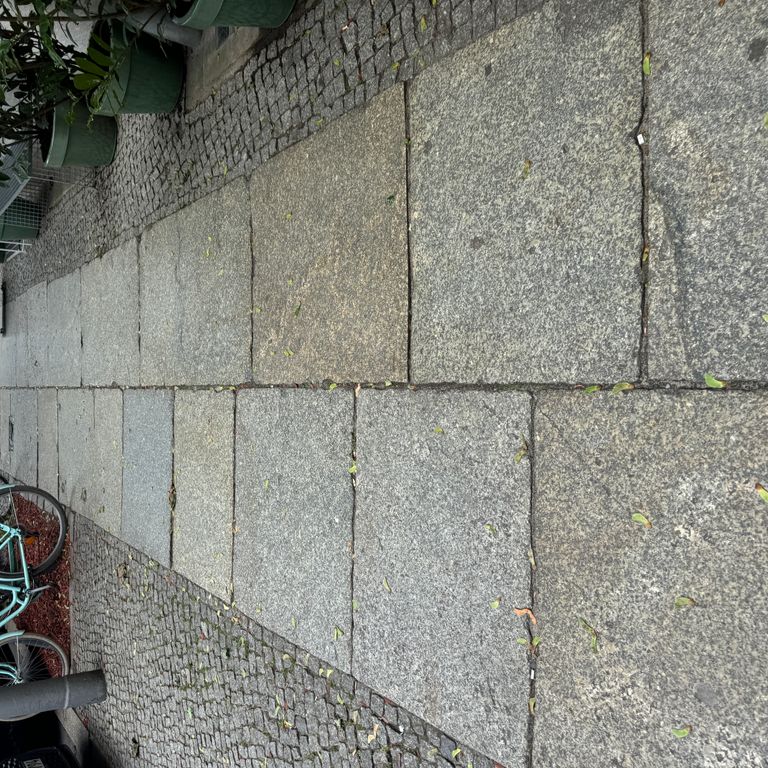 Application image for Granite - Reclaimed Berlin Sidewalk Stones. The image shows this product being used in a path pavers application. The surface finish shown is . The dominant color shown is gray. The color mix creates a warm feeling.