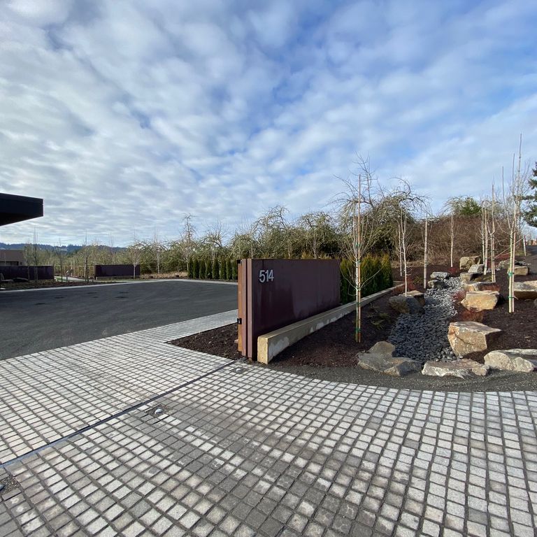 Application image for Pensy Black Granite Cobblestones. The image shows this product being used in a driveway pavers application. Dominant colors shown are black and gray.