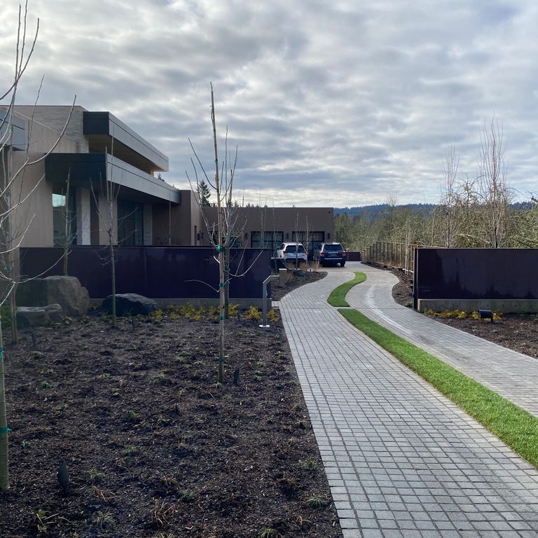 Application image for Pensy Black Granite - Flamed Cobblestones. The image shows this product being used in a driveway pavers application. Dominant colors shown are black and gray.