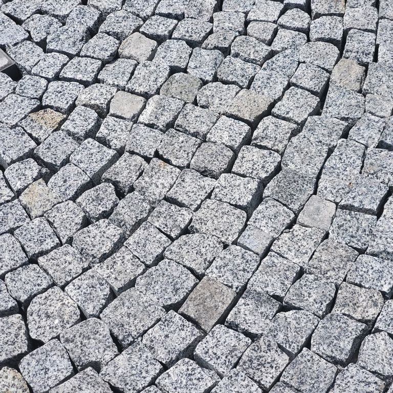 Application image for White House Granite - Tumbled Cobblestones. The image shows this product being used in a patio pavers application. Dominant colors shown are gray and white. The color mix creates a cool feeling.
