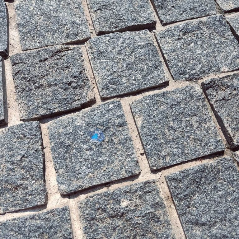 Application image for Labradorite Blue Seven Oceans - Natural Cobblestones. The image shows this product being used in a patio pavers application. The surface finish shown is split-face. The dominant color shown is gray. The color mix creates a cool feeling.
