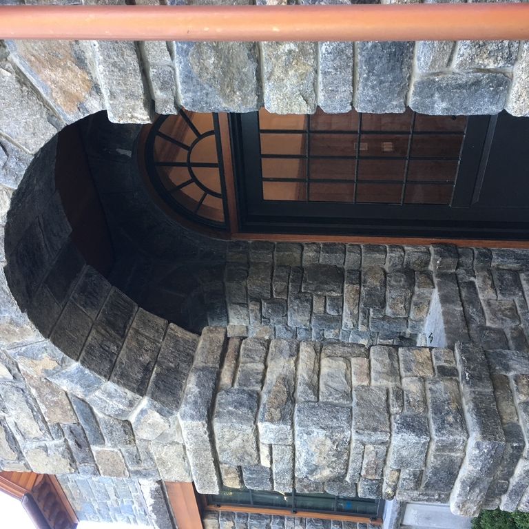 Application image for New England Fieldstone - Barre Dark Veneer. The image shows this product being used for full bed veneer and thin veneer. The surface finish shown is weathered. Dominant colors shown are gray and tan. The color mix creates a cool feeling.