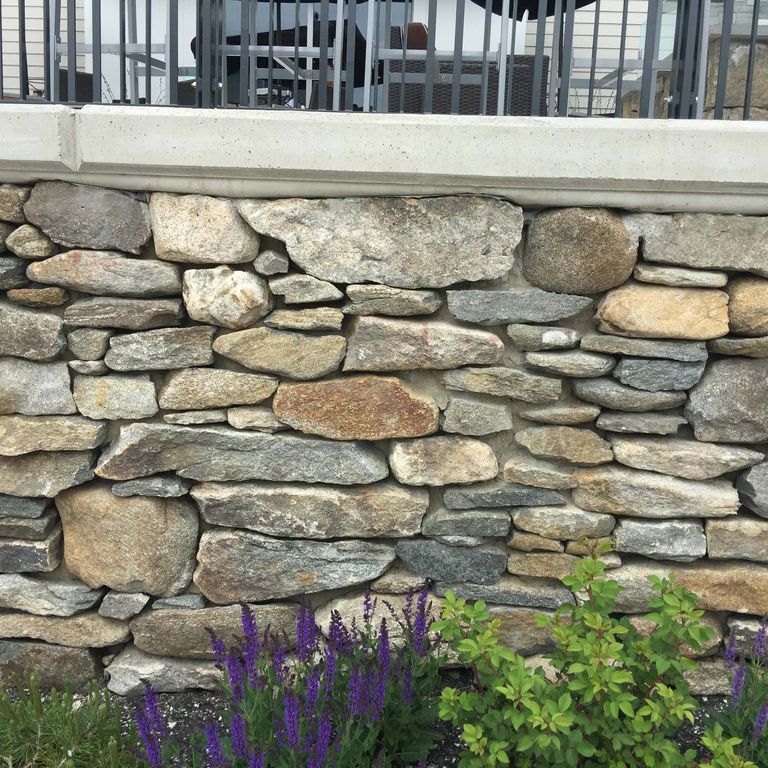 Application image for New England Fieldstone - Barre Dark Veneer. The image shows this product being used in a thin veneer application. The surface finish shown is weathered. The dominant color shown is gray. The color mix creates a warm feeling.