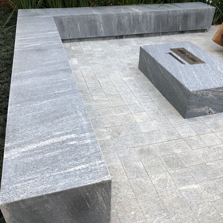 Feature image for Brazilian Lucerna Gneiss - Benches. The image shows this product being used in a seating & benches application. The surface finish shown is flamed. The dominant color shown is gray. The color mix creates a warm feeling.
