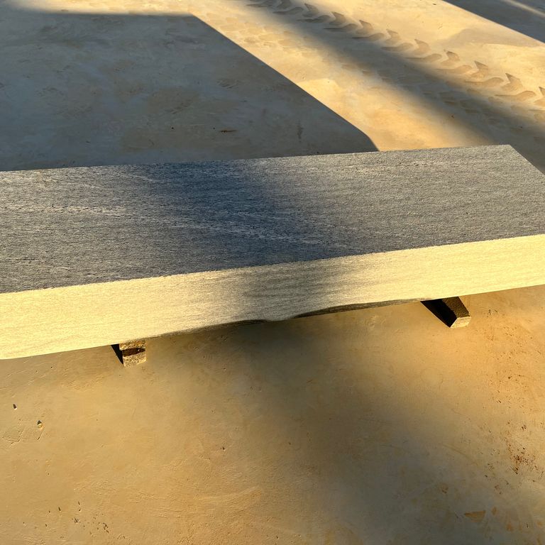 Application image for Brazilian Lucerna Gneiss - Benches. The image shows this product being used in a seating & benches application. The surface finish shown is flamed. The dominant color shown is gray. The color mix creates a cool feeling.