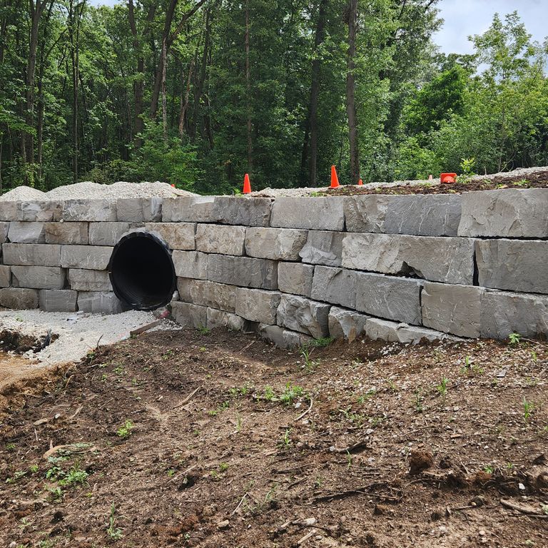 Application image for Lannon Gray Limestone - Wallstone. The image shows this product being used for landscape wallstone and retaining wall. The surface finish shown is natural cleft. The dominant color shown is gray. The color mix creates a warm feeling.